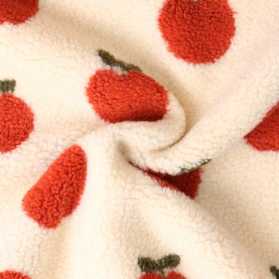 Tissu Fausse fourrure Mouton Romy pommes Rouges sur fond Ecru - Par 10 cm