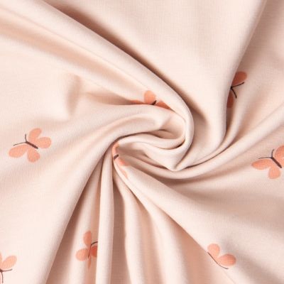 Tissu Jersey Coton imprimé Iris papillons Saumon sur fond Rose pastel - Par 10 cm